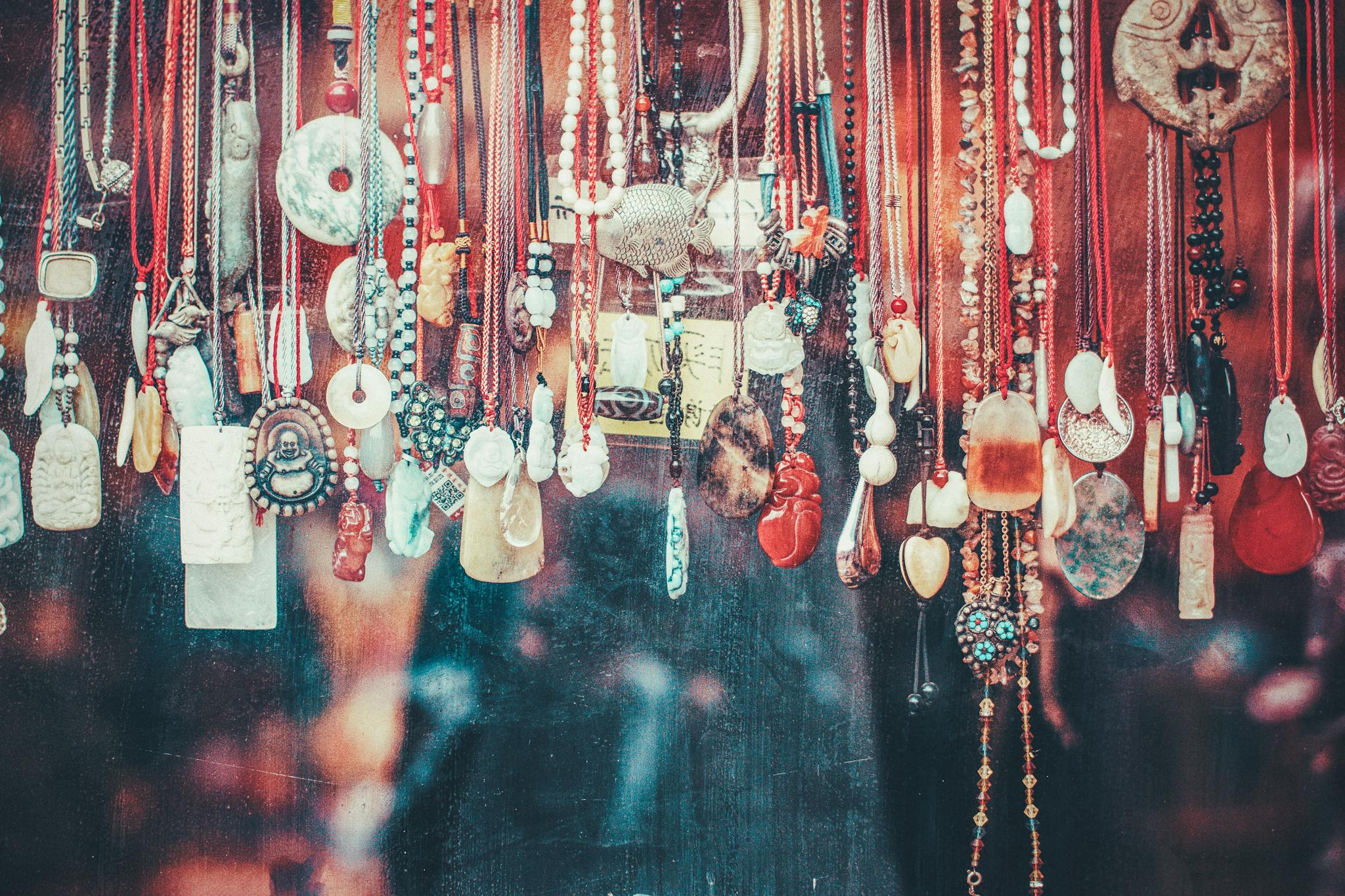 Vibrant collection of various pendants hanging in a Beijing market. A display of cultural and artistic jewelry.